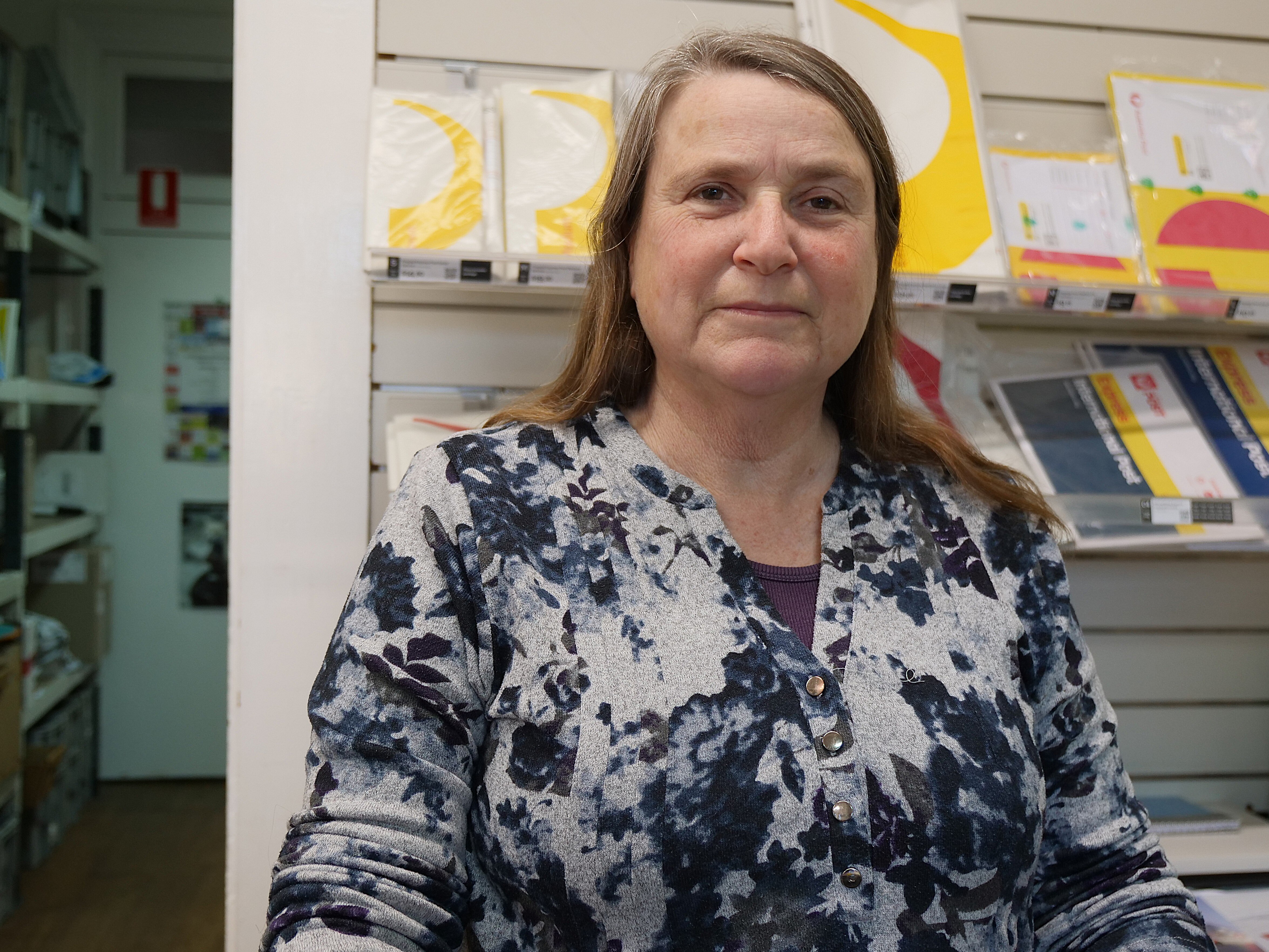 Una mujer se encuentra en una oficina de correos.