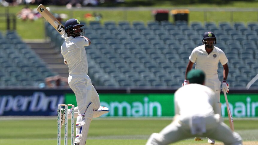 Cheteshwar Pujara watches his shot go over the slips as batting partner Ravi Ashwin watches on.