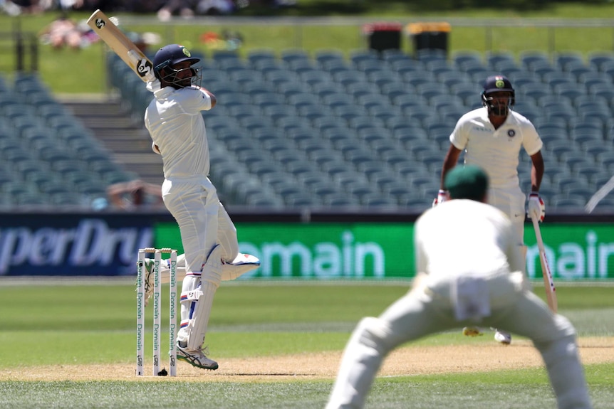 Cheteshwar Pujara watches his shot go over the slips as batting partner Ravi Ashwin watches on.