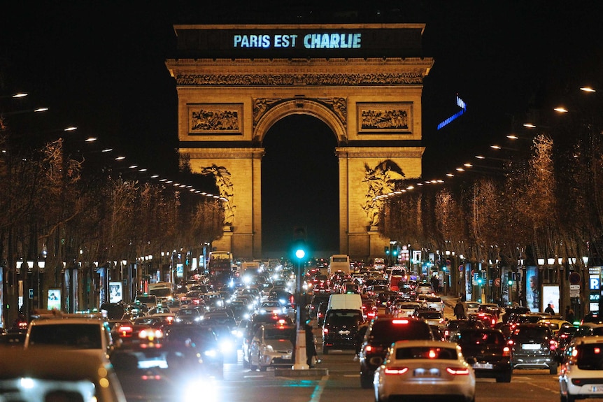 Paris est Charlie" (Paris is Charlie) is projected onto the Arc de Triomphe