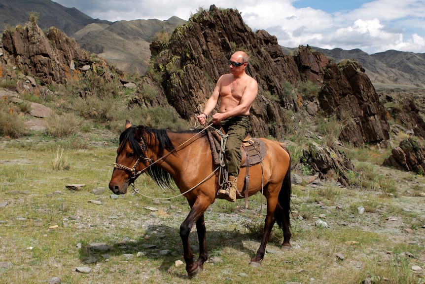 Vladimir Putin shirtless on horseback in Siberian mountains.
