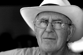 Black and white of older man in white large brimmed hat