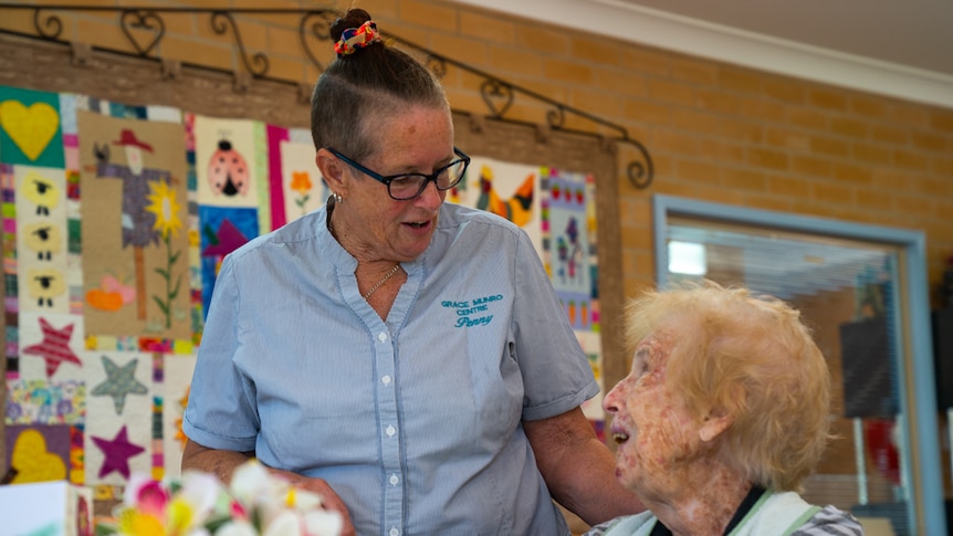 Registered Nurse Penny Abbington stands next to an aged care resident