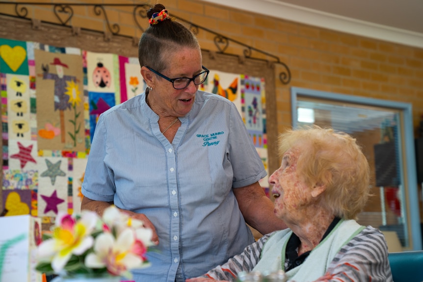 Registered Nurse Penny Abbington stands next to an aged care resident