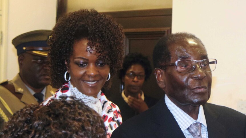 Grace and Robert Mugabe greet people at a meeting.