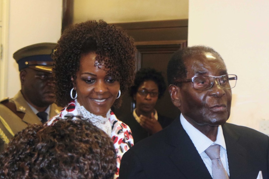 Grace and Robert Mugabe greet people at a meeting.