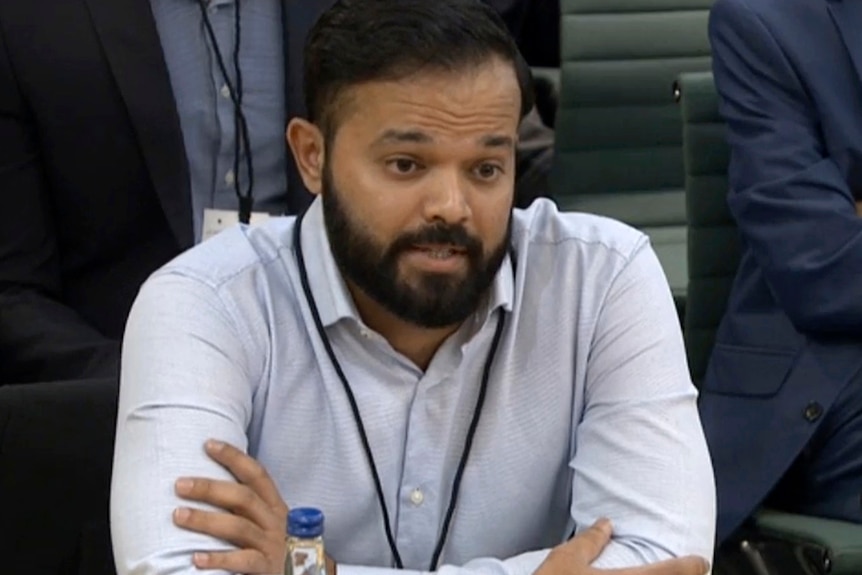 A screenshot of Azeem Rafiq speaking while sitting at a hearing