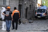 Turkish forensic investigators work near debris from rocket fire.