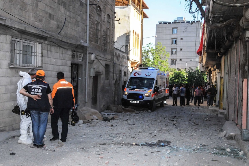 Turkish forensic investigators work near debris from rocket fire.