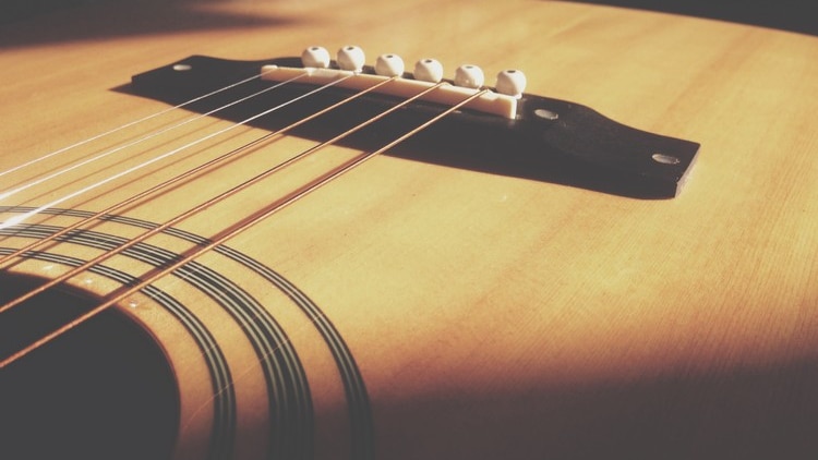 the strings of an acoustic guitar