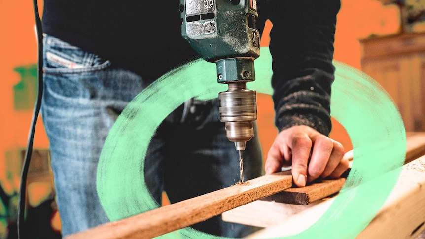 A person drills into a piece of wood using an electric drill for a story about how to avoid DIY mistakes at home.