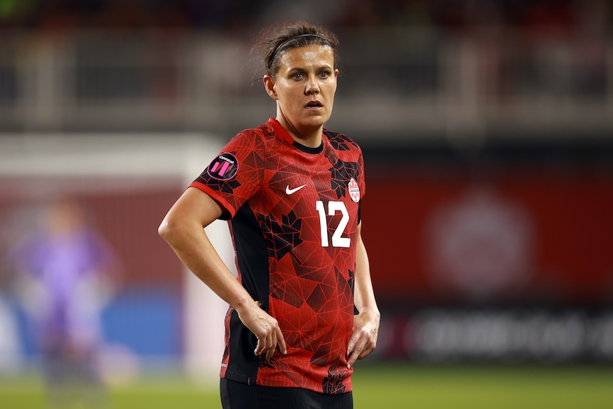 A woman in a red soccer jersey.