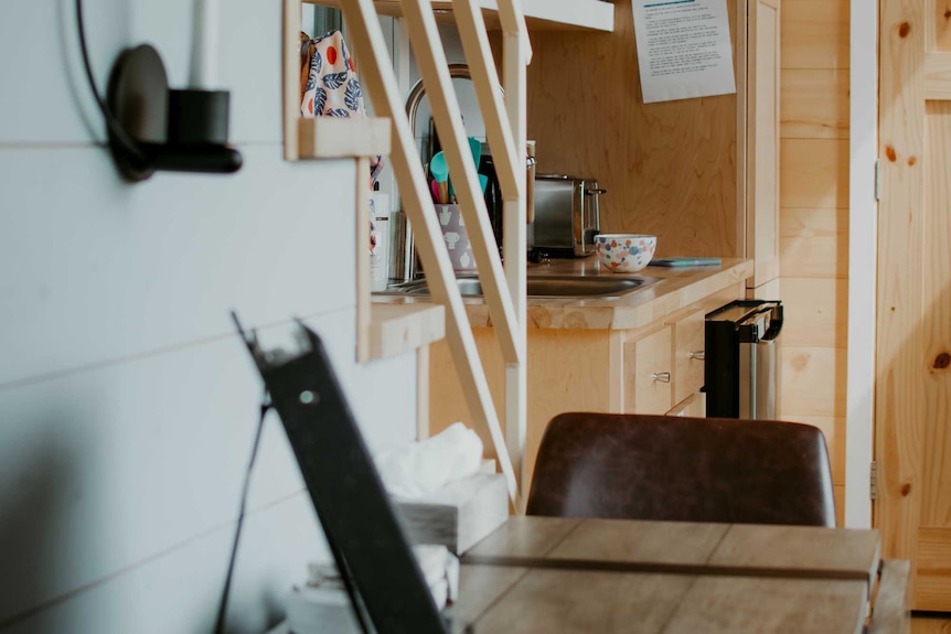 Table, stairs and kitchen in a tiny house