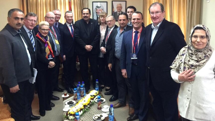 Bunched group photo of Australian led delegation and members of the Palestinian Authority in a room in Ramallah.
