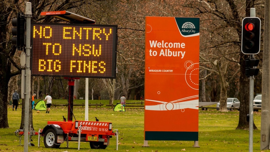 A sign saying no entry to nsw big fines next to a sign saying welcome to albury.