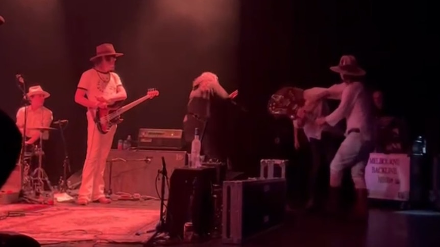 Anton Newcombe takes Ryan Van Kriedt's guitar and swings it at the guitarist on stage at the Forum in Melbourne