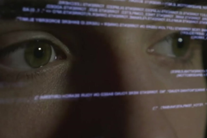 Eyes reflected on a computer screen with data on it.