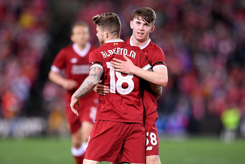 Alberto Moreno (L) is congratulated by Ben Woodburn after scoring a goal.