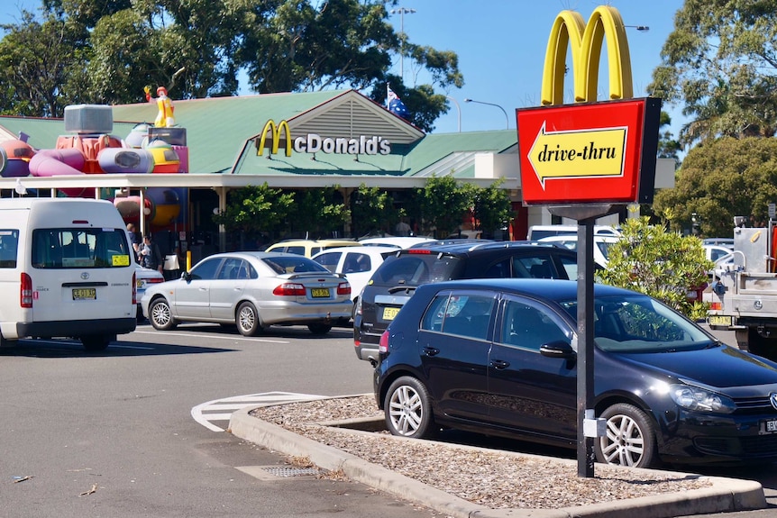 Cars in a car park of fast food restaurant McDonalds.