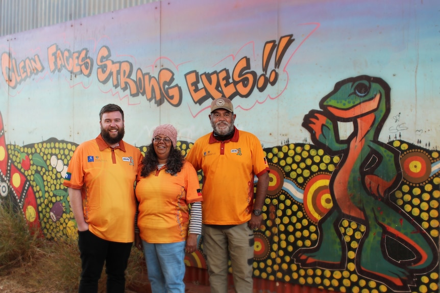 Nick Wilson, Walter Bathern and Lesley Martin standing in front of a mural.
