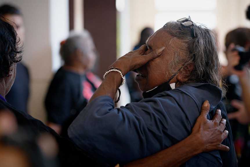  A woman cries into her hands outside of the NT Supreme Court.