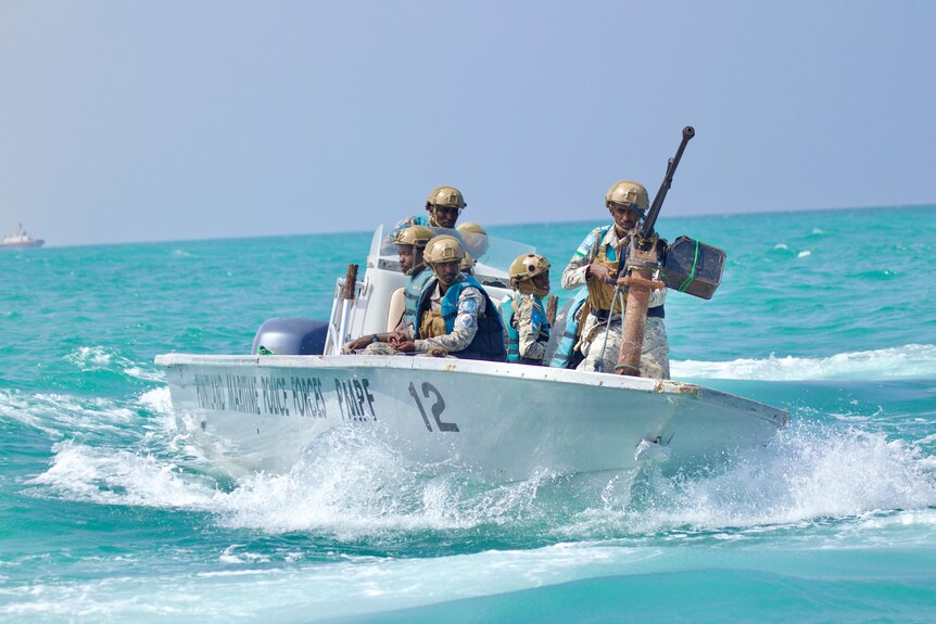 Somalian maritime personnel on a speed boat mounted with a large calibre machine gun. 