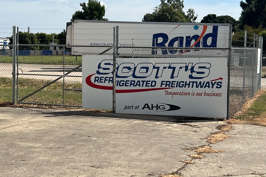 A sign on a fence at a freight depot.