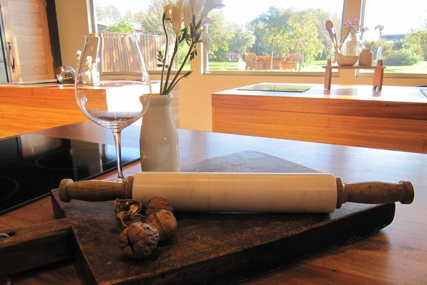 oblong cooking stations with ovens, vintage rolling pins and wine glasses stand in front of big glass windows