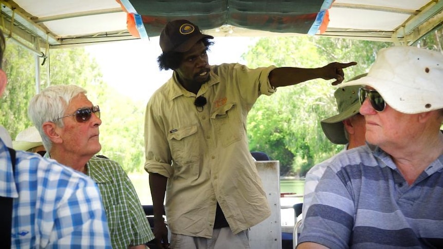 Kakadu Tour Guide Robert Namarnyilk points out of a boat full of tourists