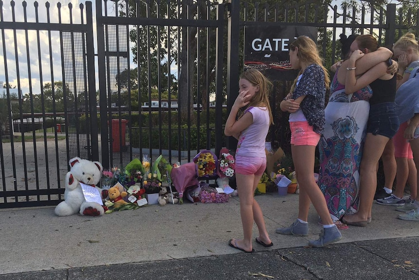 Mourners place flowers and toys outside Marsden State High School to honour 12-year-old suspected murder victim Tiahleigh Palmer