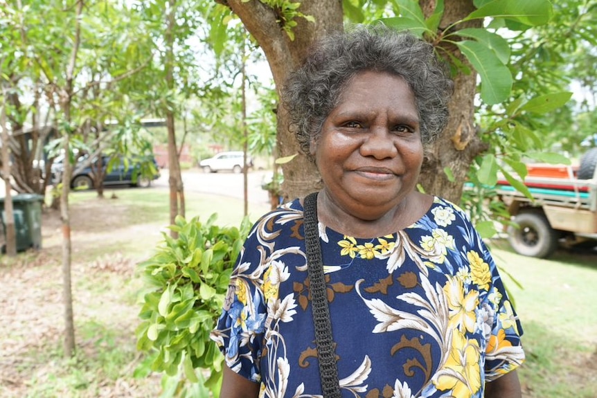 Annie Ngalmirama stands by a tree