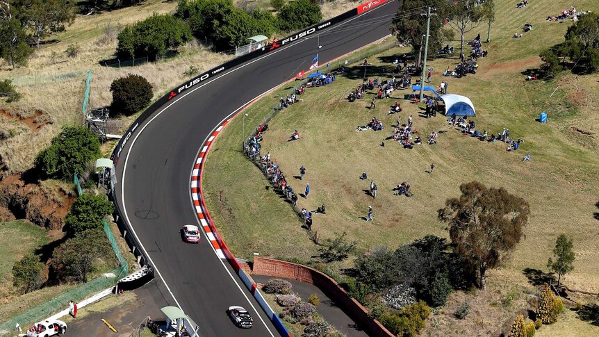 Two V8 super cars charge over the top of Mount Panorama during the Bathurst 1000.