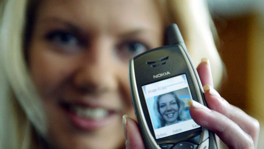 A woman holds the Nokia 6650