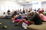 Players, coaches and staff at the National Tennis Academy clapping for John Millman as they watch the match on television.