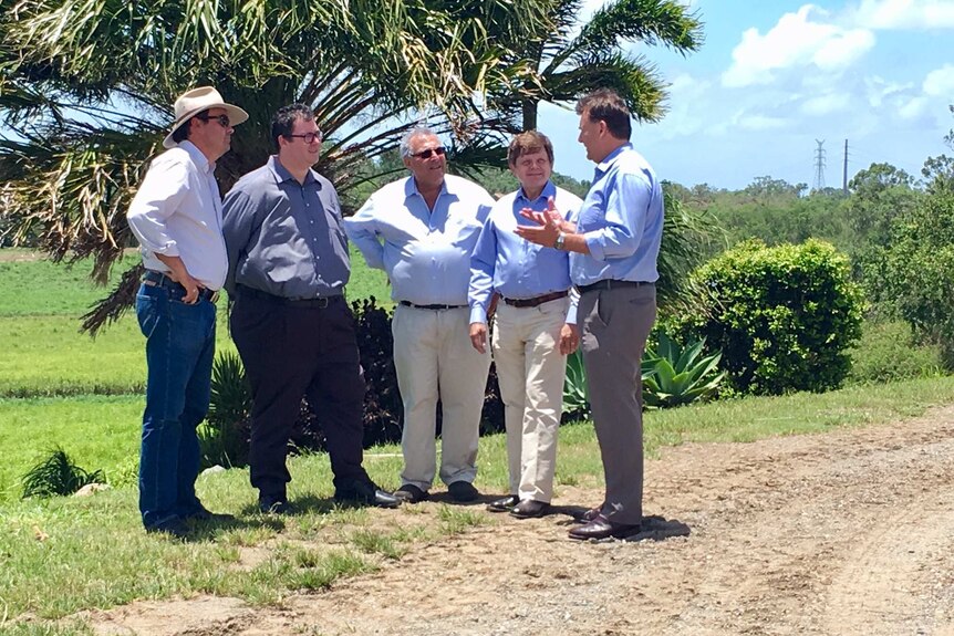 Paul Schembri from Canegrowers speaks to politicians in a field near Mackay