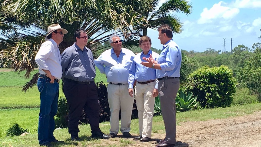 Paul Schembri from Canegrowers speaks to politicians in a field near Mackay