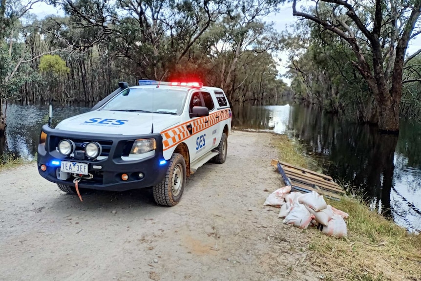 A ute is parked by floodwaters.