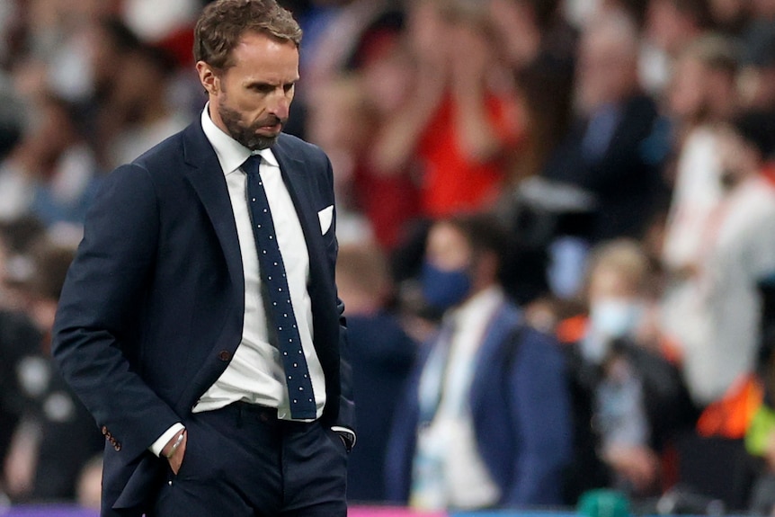 Gareth Southgate stands, hands in pockets, looking at the ground