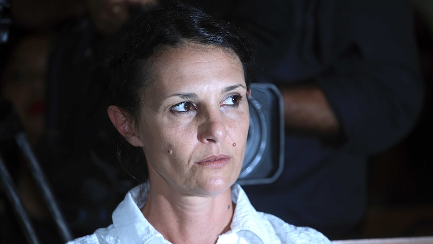 Sara Connor sits in court, a television camera is positioned behind her head