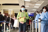 A woman wearing a mask walks through a security cordon