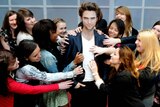 A group of girls pose next to a wax model of Robert Pattinson