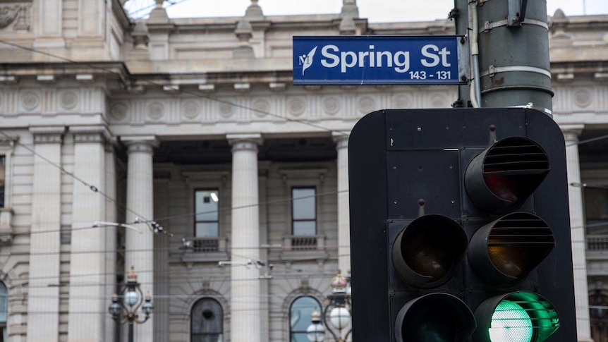 Victorian Parliament with Spring St sign and green traffic light in foreground