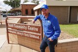 A man stands beside a sign that says South Community Centre in Broken Hill.