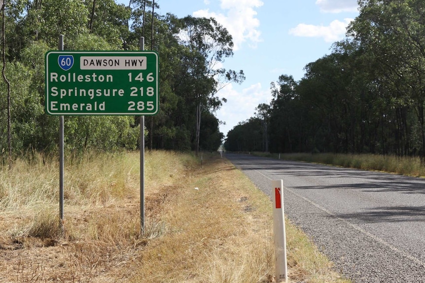 Green street sign on the Dawson Highway on the way out of Moura shows distance from Moura to Rolleston, Springsure and Emerald