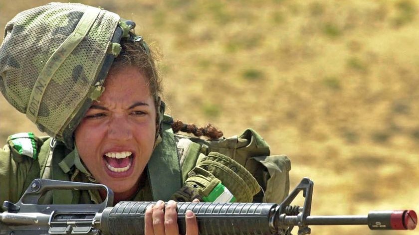 An Israeli army female soldier shouts while holding a M16 rifle on May 23, 2005.