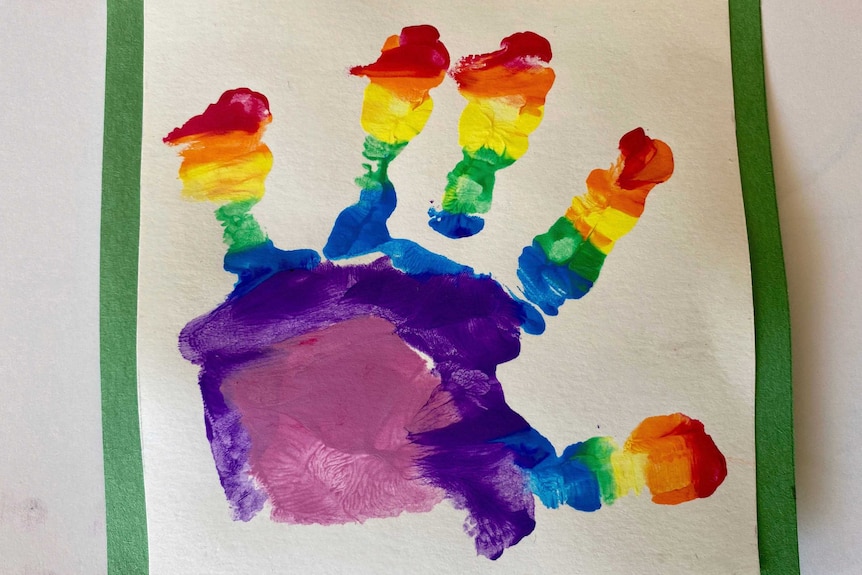 A hand print belonging to Prince Louis in rainbow paint is photographed.
