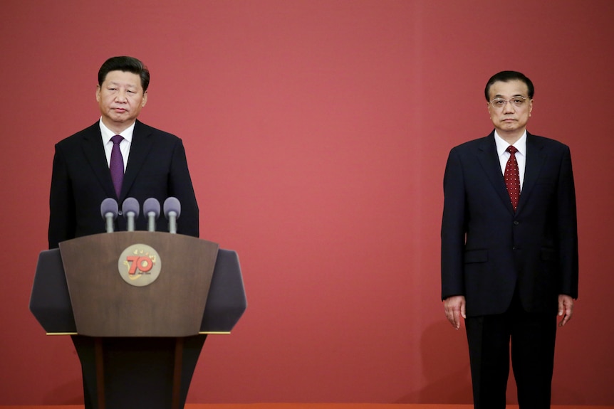 Xi Jinping standing in front of a lectern while Xi Jinping stands to one side
