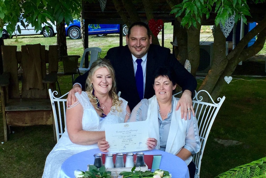 Celebrant Jason Brett with his arms around newlyweds Lainey Carmichael and Roz Kitschke.