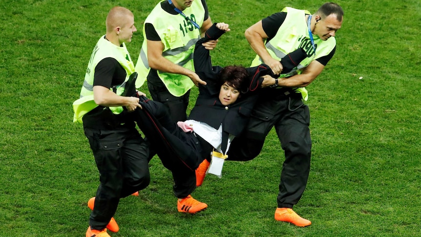 Stewards grab a pitch invader during the World Cup final.