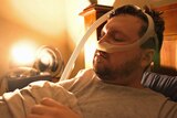 Jonathan Brown lies in bed with a tube attached to his nose.